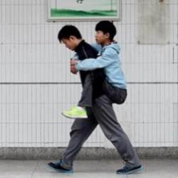 Одноклассник носит своего друга-инвалида на руках в школу и домой
